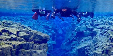 Two people snorkelling in Silfra in Iceland