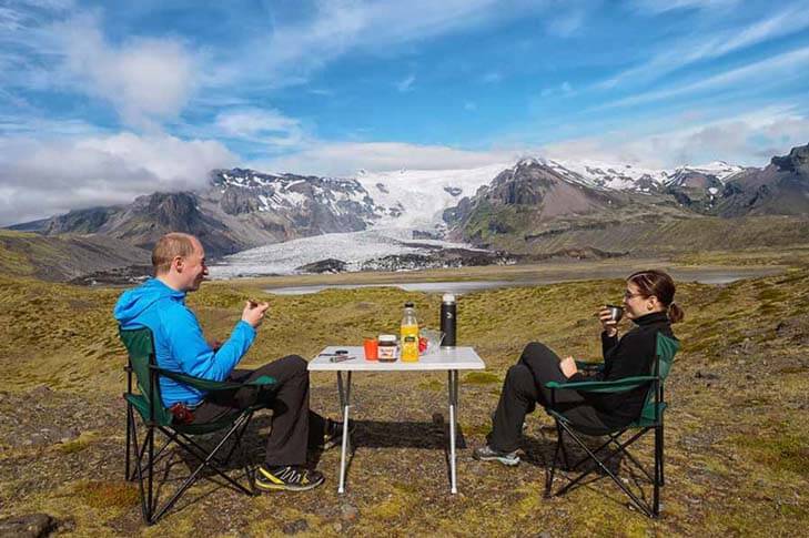 two people camping next to a glacier