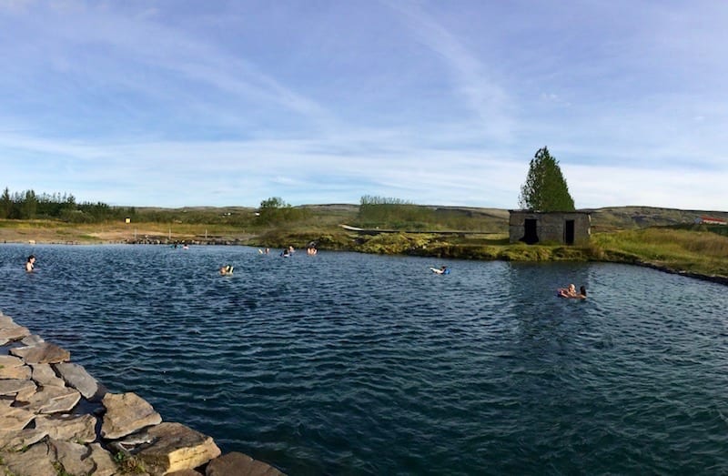 People swimming in Secret Lagoon in summer