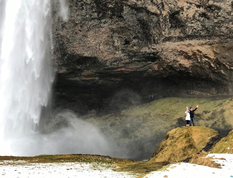 A couple poses in front of Seljalandsfoss