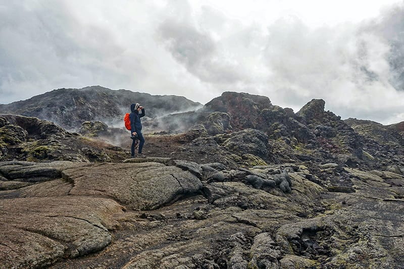 man standing in the middle of lava field