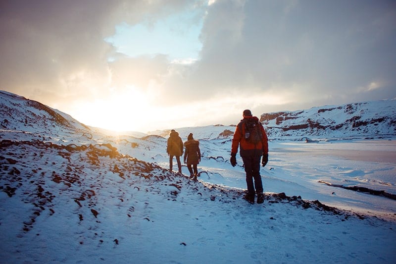 A group of people hiking on a mountain during winter.