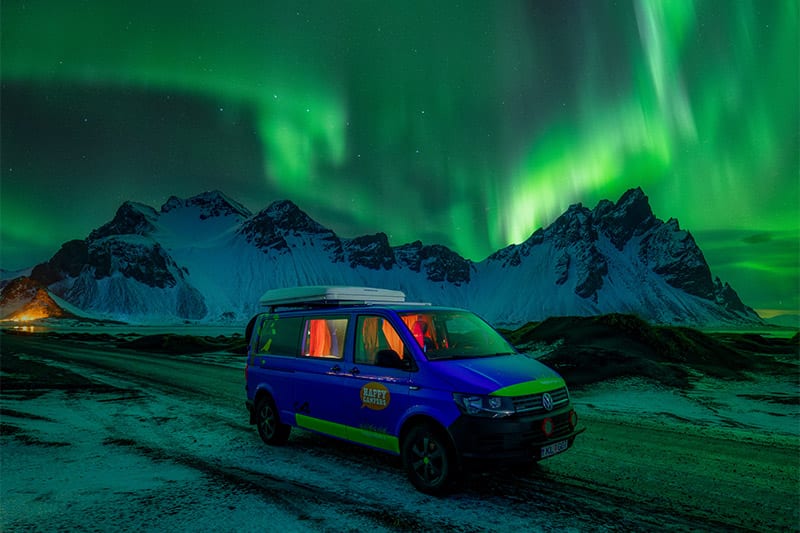 Happy 4x4 camper under norther lights in Iceland