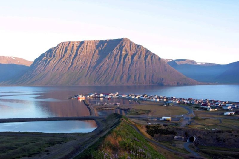 fjors with high mountain at the centre and a small fishing town on a peninsula
