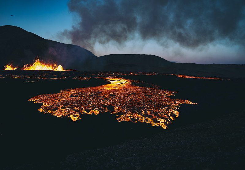 photo of hot lava flowing from volcanic fissures in the dark