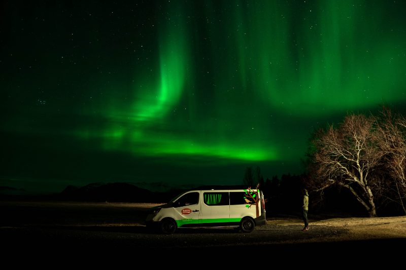 Campervan parked under the Northern Lights on a trip to Iceland in April