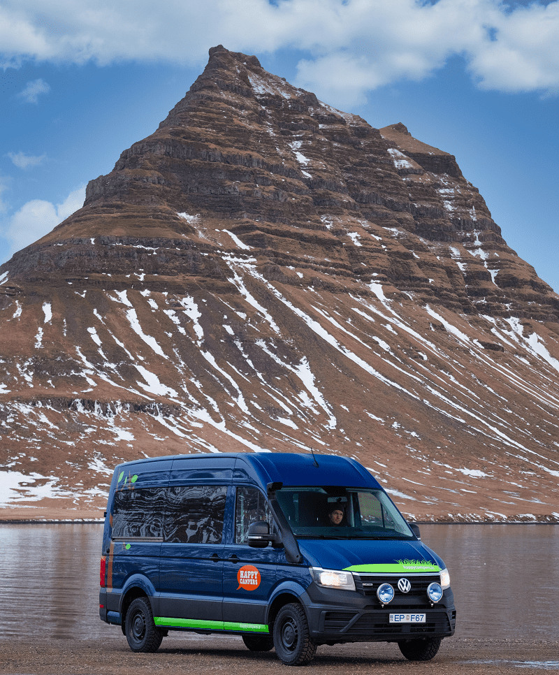 dark blue happy 4x4 xl campervan parked in front of Kirkjufell mountain in Iceland