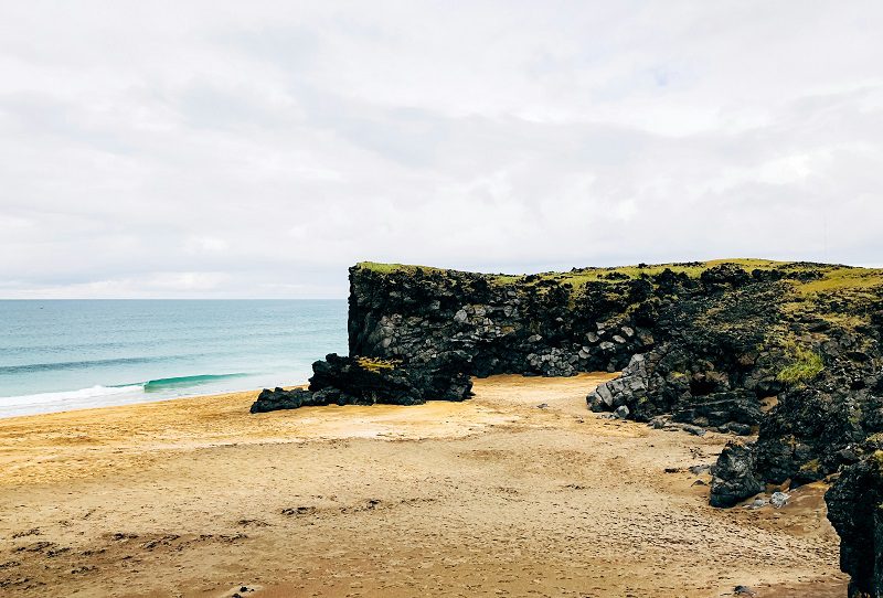 Photo of Skardsvik cove beach with golden sand and black lava fields in Snaefellsnes peninsula 